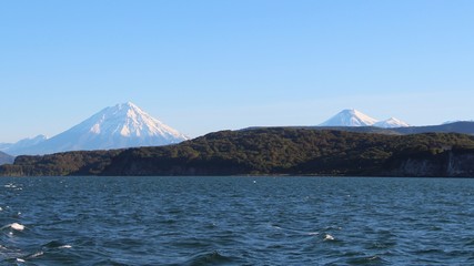Avachinsky and Koryaksky volcanoes rises above the coastline of the Kamchatka Peninsula.