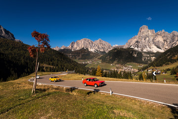 oldtimer in autumn on a pass road with blue sky