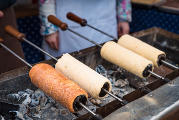 delicious chimney cake on a wooden mold is baked on the grill