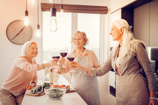Happy cheerful women holding glasses of wine