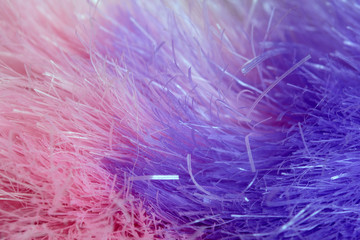 Abstract violet-pink background of artificial hairs. Close-up shot.