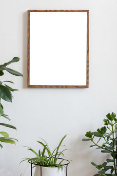 Scandinavian and botanical interior with brown mock up poster frame on the white wall. White backgrounds walls. Modern and floral concept. Nature lover. 