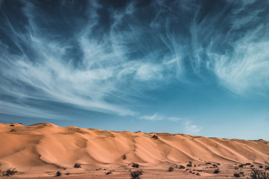 Magic sky in the Sahara Desert, blue sky and white clouds over the gold sandy dunes