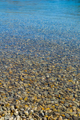 Pebbles under water at edges of river
