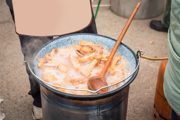fresh traditional pork cracklings are cooked in the cauldron outside
