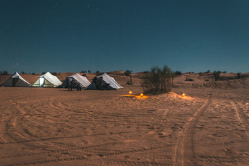 Amazing adventure trip in the Sahara desert, tent camp among the dunes under starry sky
