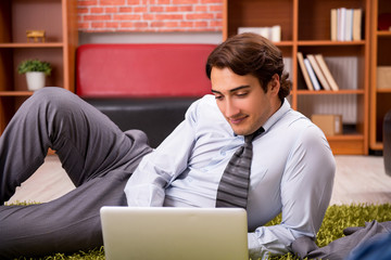 Young employee lying on the floor at office 