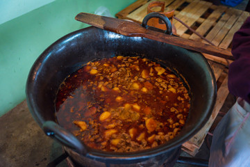 fresh pork cracklings are cooked in the cauldron outside