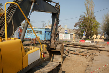 repair of a pipe, an excavator on the road