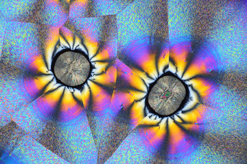 Photo through a microscope of crystals grown from a solution of ascorbic acid in alcohol. Polarized light technology.