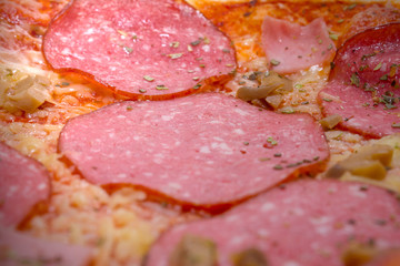 Pepperoni pizza close-up with slices of mushrooms and vegetables