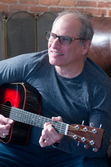 Obraz premium middle age senior man playing guitar