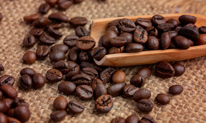 Coffee beans lie wooden spoon.