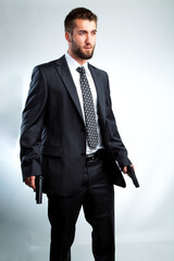 Portrait eines bärtigen Mannes in Anzug und mit zwei Pistolen