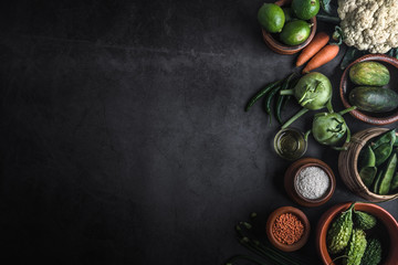 Various vegetables on a black table with space for a message