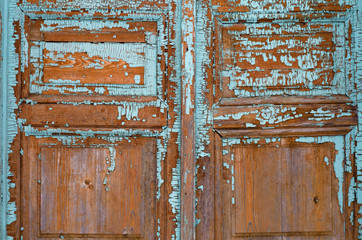 Close-up  of an old wooden door with  blue peeling paint