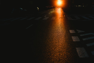 Urban background of a dark street at dusk with cars and traffic marks