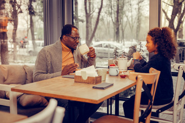 Father and daughter eating and drinking tea together after walking
