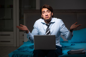 Tired businessman working overtime at home at night