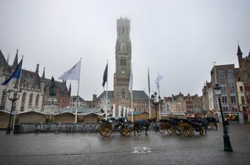 Bruges/Belgium - December 31 / 2016  :  Horse carts are wating for the customers in front of Belfry...