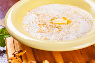 Oatmeal porridge with nuts, jam and fruits on wooden board