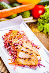 Salad with eel, carrot, red onion, sesame seeds on white plate