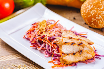 Salad with eel, carrot, red onion, sesame seeds on white plate