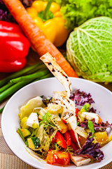 Fattoush salad with different vegetables on white plate