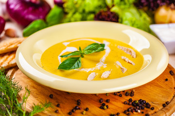 Cheese cream soup with chicken on wooden board