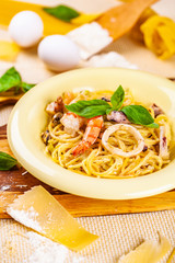 Spaghetti with seafood and parmesan cheese in beige plate