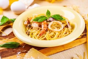 Spaghetti with seafood and parmesan cheese in beige plate