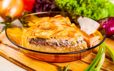 Meat pie with potato and onion in glass bowl