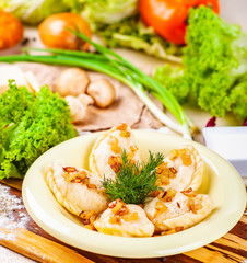 Vareniki with potatoes and mushrooms decorated with fried onion and dill