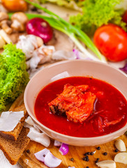 Borscht with vegetables and meat in pink plate. Ukrainian cuisine