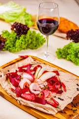 Different italian meat with pear slices and pickles on wooden cutting board