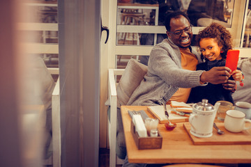 Father and daughter having much fun while making selfie together