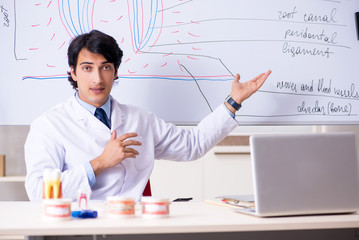 Young handsome dentist in front of the whiteboard 