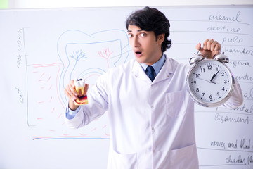 Young handsome dentist in front of the whiteboard 