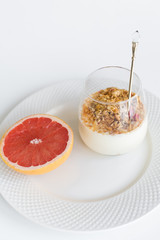 Healthy breakfast. Ingredients: grapefruit, granola. Side view, white background.