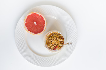 The concept of a healthy Breakfast. Ingredients: grapefruit, granola, yogurt. Top view, white background.