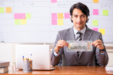 Young handsome employee working in the office