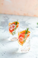 Alcoholic cocktail with grapefruit, soda, ice, gin and rosemary