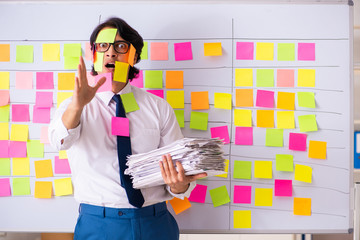 Young employee in conflicting priorities concept 