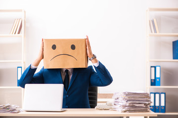 Unhappy man employee with box instead of his head 