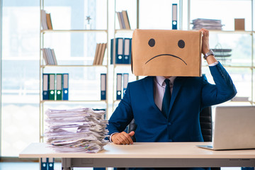 Unhappy man with box instead of his head 