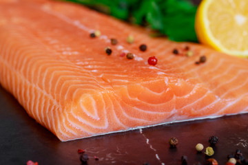 Fresh salmon on the black cutting board.