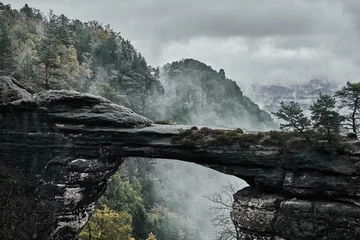 Foto op Plexiglas Mistige mistige landschap van de Pravcicka-poort (Pravcicka brana) de grootste natuurlijke zandstenen boog in Europa in Tsjechisch Zwitserland (Boheems Zwitserland of Ceske Svycarsko) Nationaal Park © Vladimir V