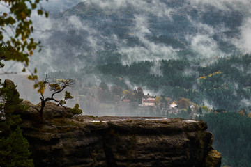 Fototapeta premium Misty rainy morning landscape with the sand rocky montains in Bohemian Saxon Switzerland in autumn colors
