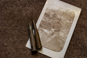 Picture of soldier siting in battlefield in period of World War I and rifle bullets on trench coat...