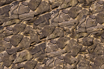 abstract background uneven base cracked lots of stones hard surface gray weather-beaten texture
